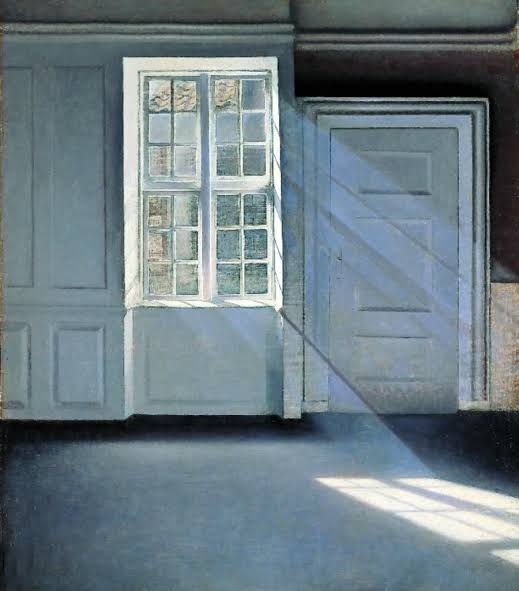 A sunlit, empty room with a white-framed window and a paneled door
